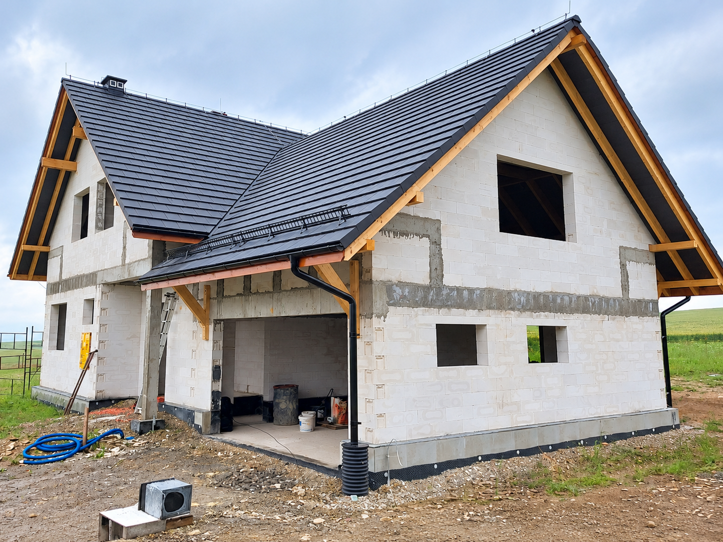 Acoperiș montat pe o casă cu finisaje exterioare în lucru.